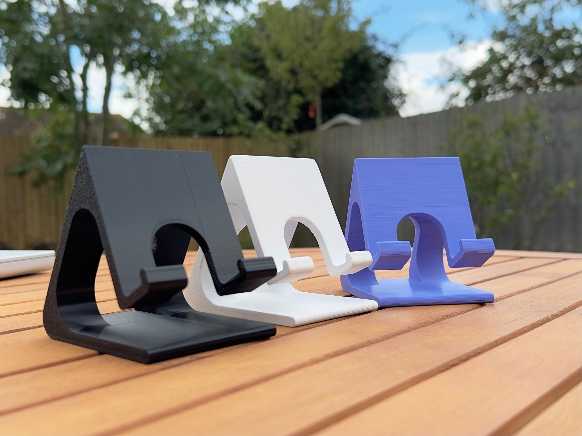 Side view of 3D printed phone stands in 3 different colors